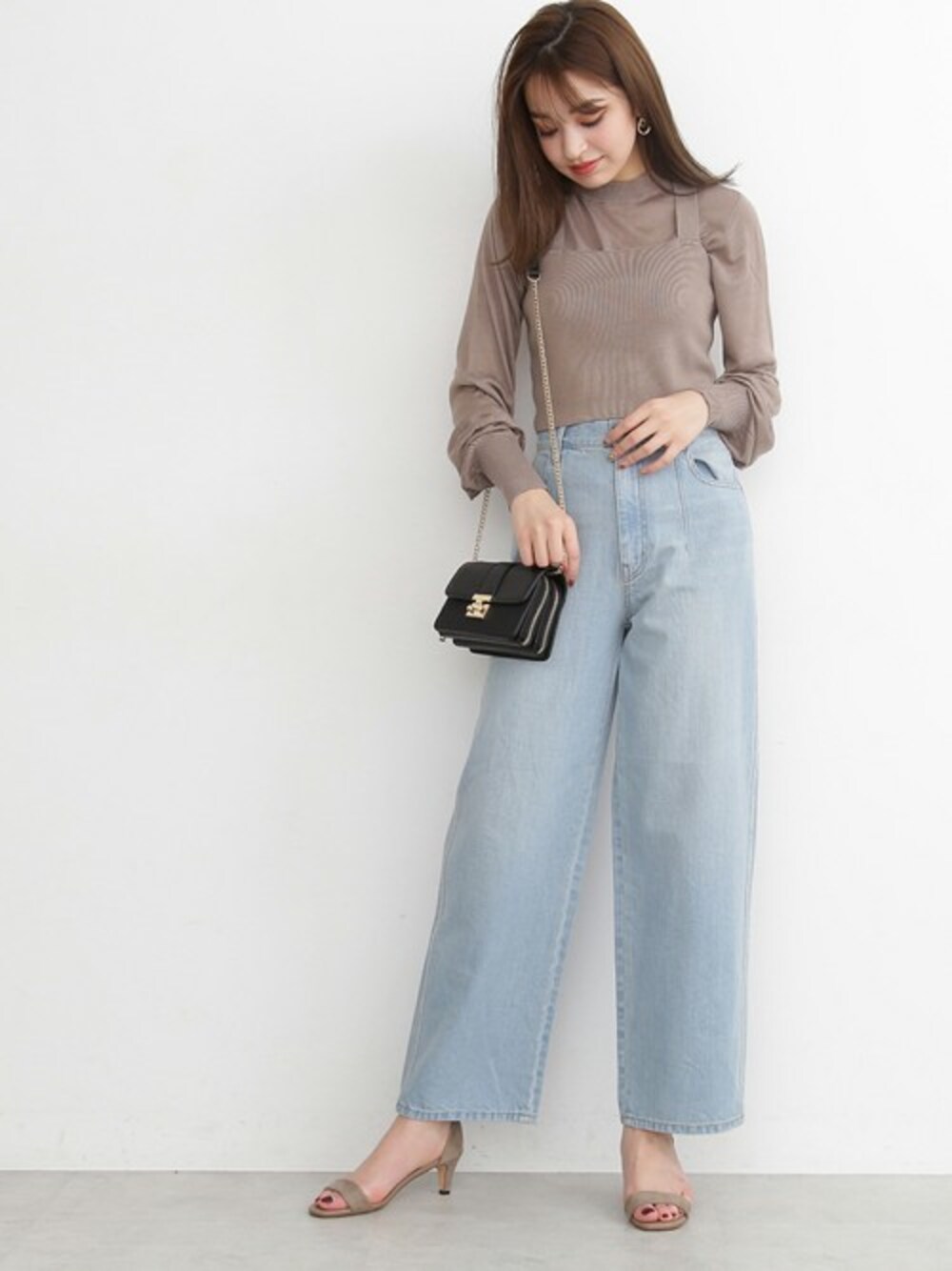 ベージュ系のニット/セーター、ブルー系のデニムパンツ、ベージュ系のサンダルを着用したレディースの春コーディネートの1枚目の写真