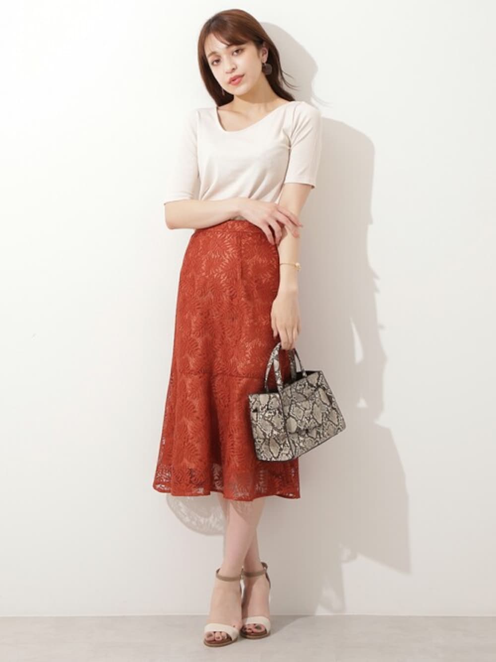 ベージュ系のTシャツ/カットソー、ブラウン系のスカート、ベージュ系のサンダルを着用したレディースの夏コーディネートの1枚目の写真