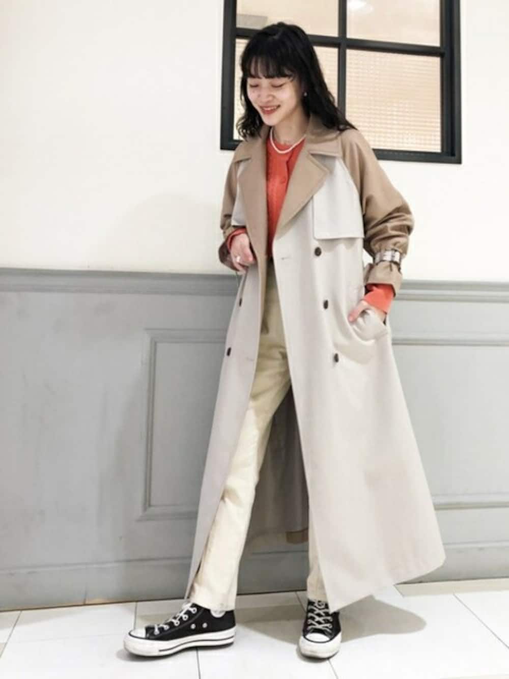 ベージュ系のトレンチコート、オレンジ系のカーディガン/ボレロ、ホワイト系のその他パンツを着用したレディースの冬コーディネートの1枚目の写真