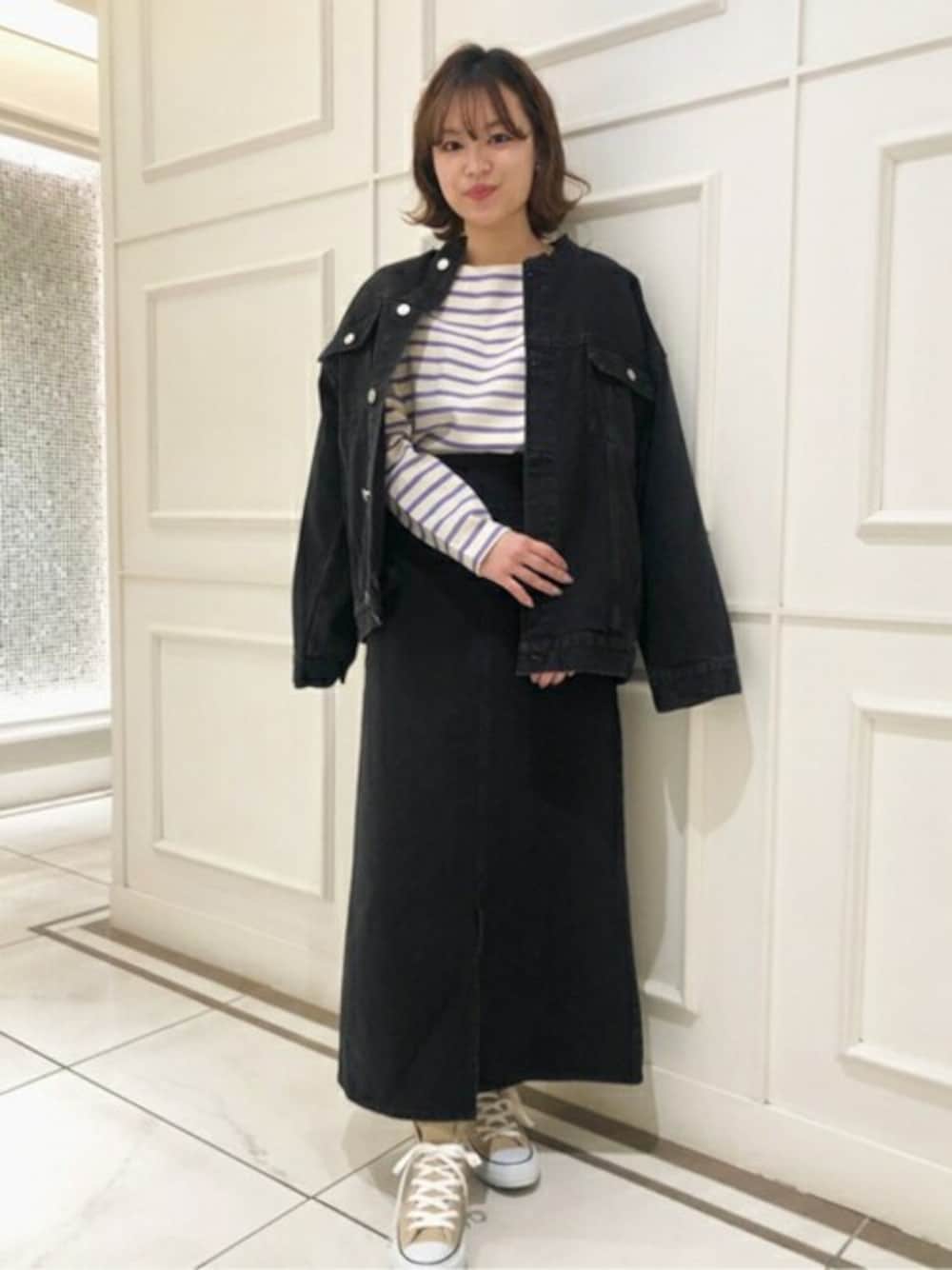 ブラック系のデニムジャケット、ブラック系のデニムスカート、パープル系のTシャツ/カットソーを着用したレディースの冬コーディネートの1枚目の写真