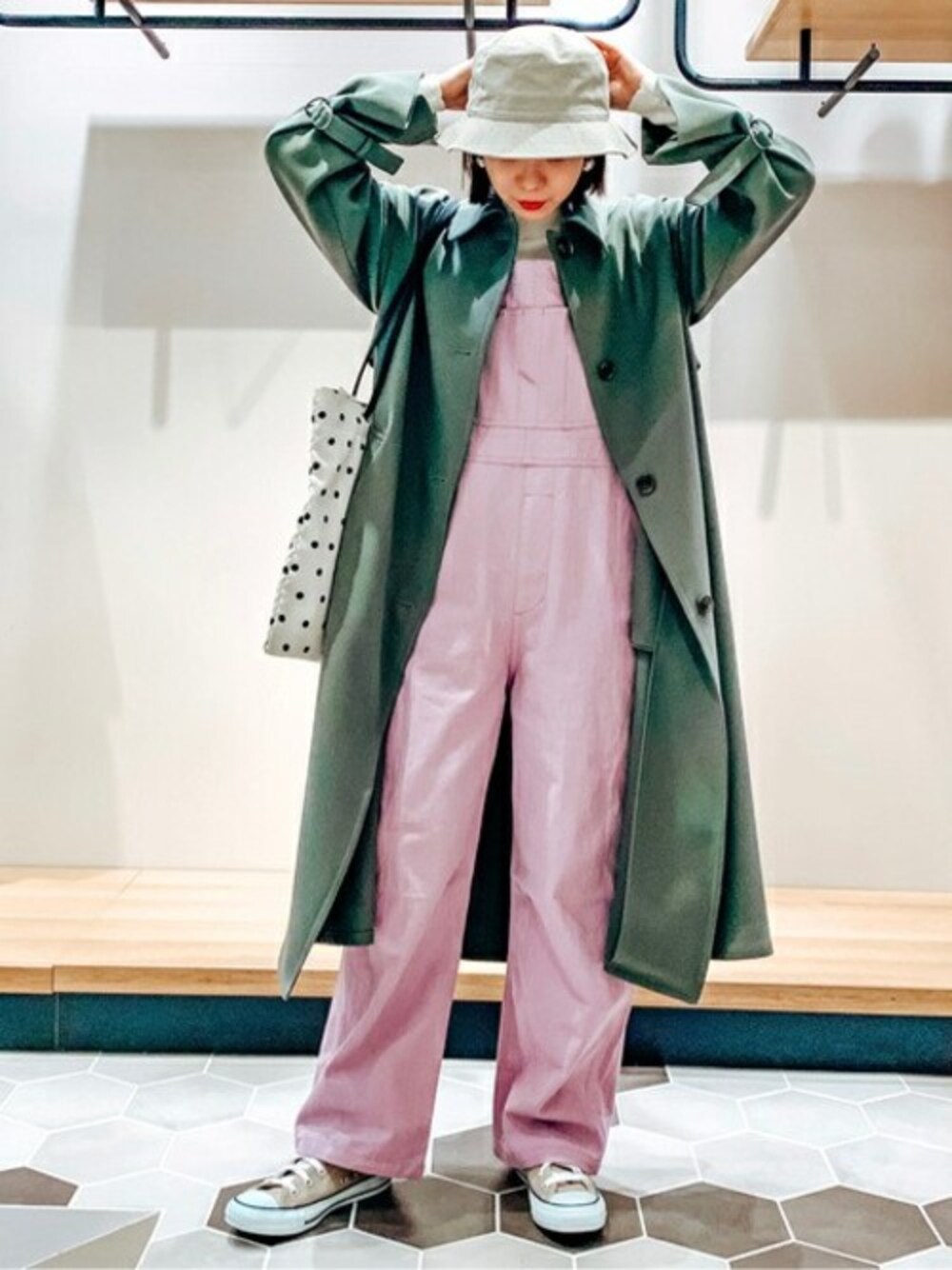 パープル系のサロペット/オーバーオール、ホワイト系のニット/セーター、グリーン系のその他アウターを着用したレディースの冬コーディネートの1枚目の写真