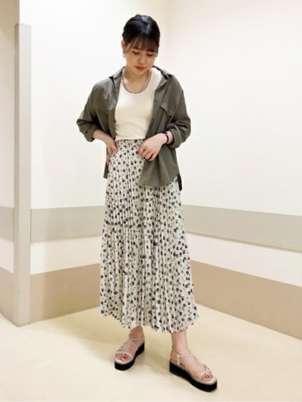 ホワイト系のスカート、ベージュ系のシャツ/ブラウス、ホワイト系のTシャツ/カットソーを着用したレディースの春コーディネートの1枚目の写真