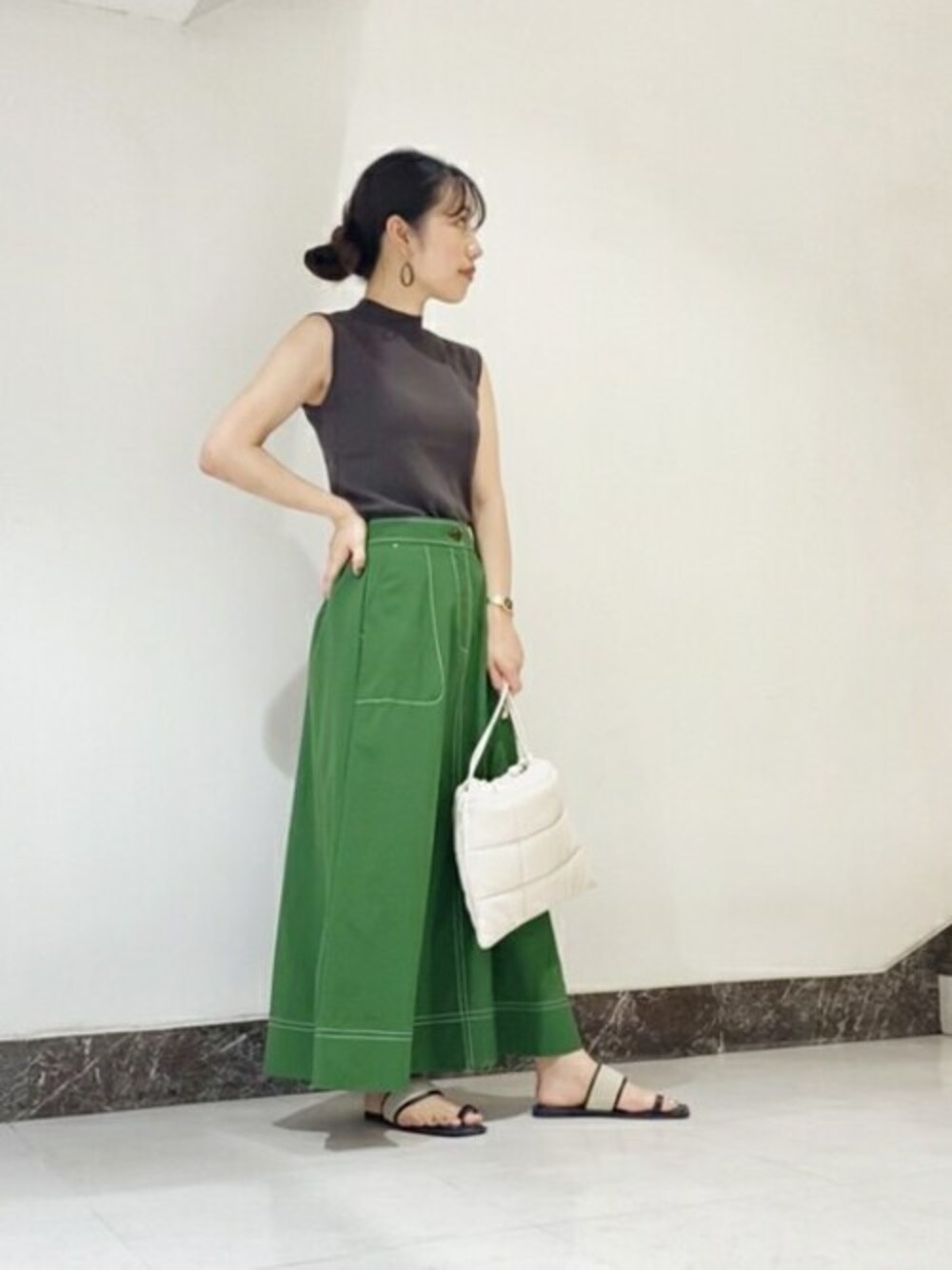 ブラウン系のニット/セーター、グリーン系のスカート、ブラック系のサンダルを着用したレディースの夏コーディネートの1枚目の写真