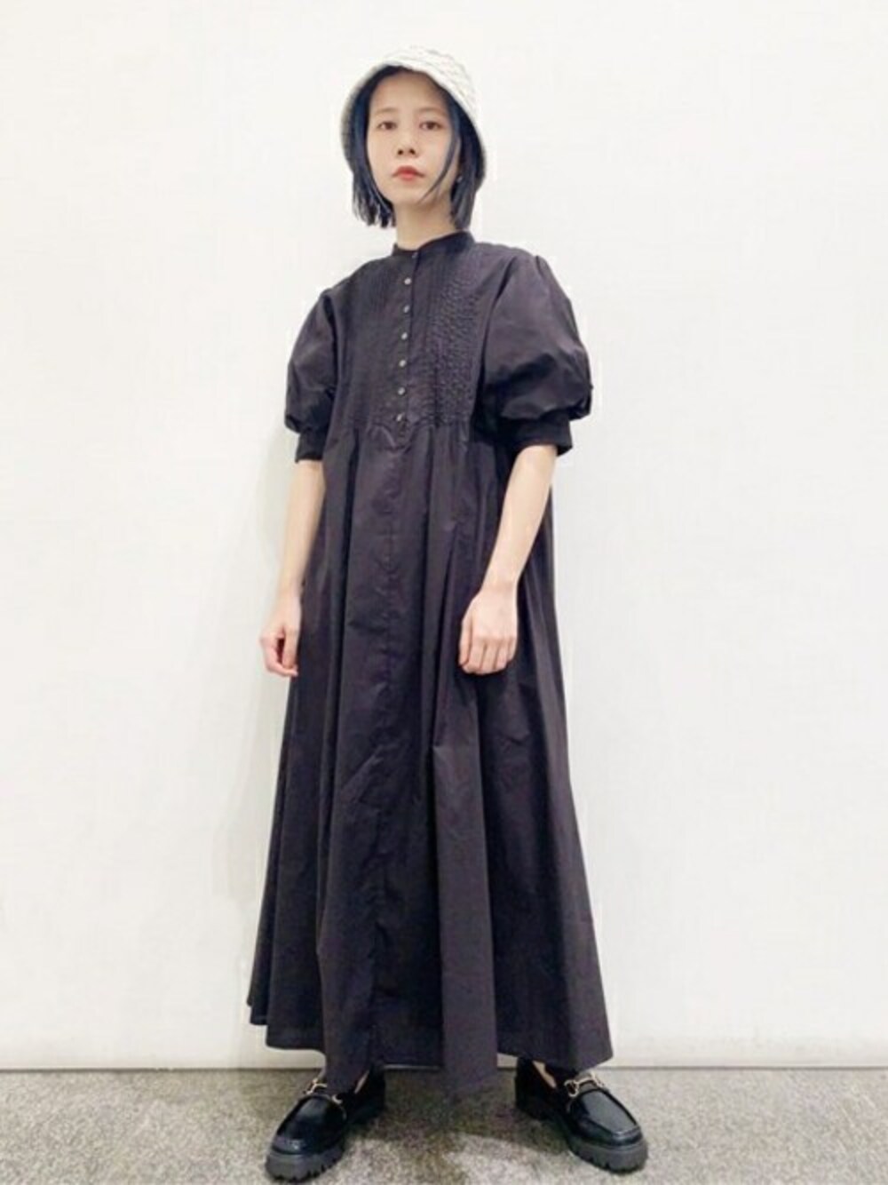 ブラック系のワンピース、ブラック系のローファーを着用したレディースの夏コーディネートの1枚目の写真