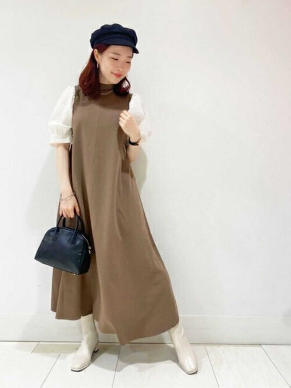 ブラウン系のワンピース、ホワイト系のブーツ、ブラック系のボストンバッグを着用したレディースの夏コーディネートの1枚目の写真