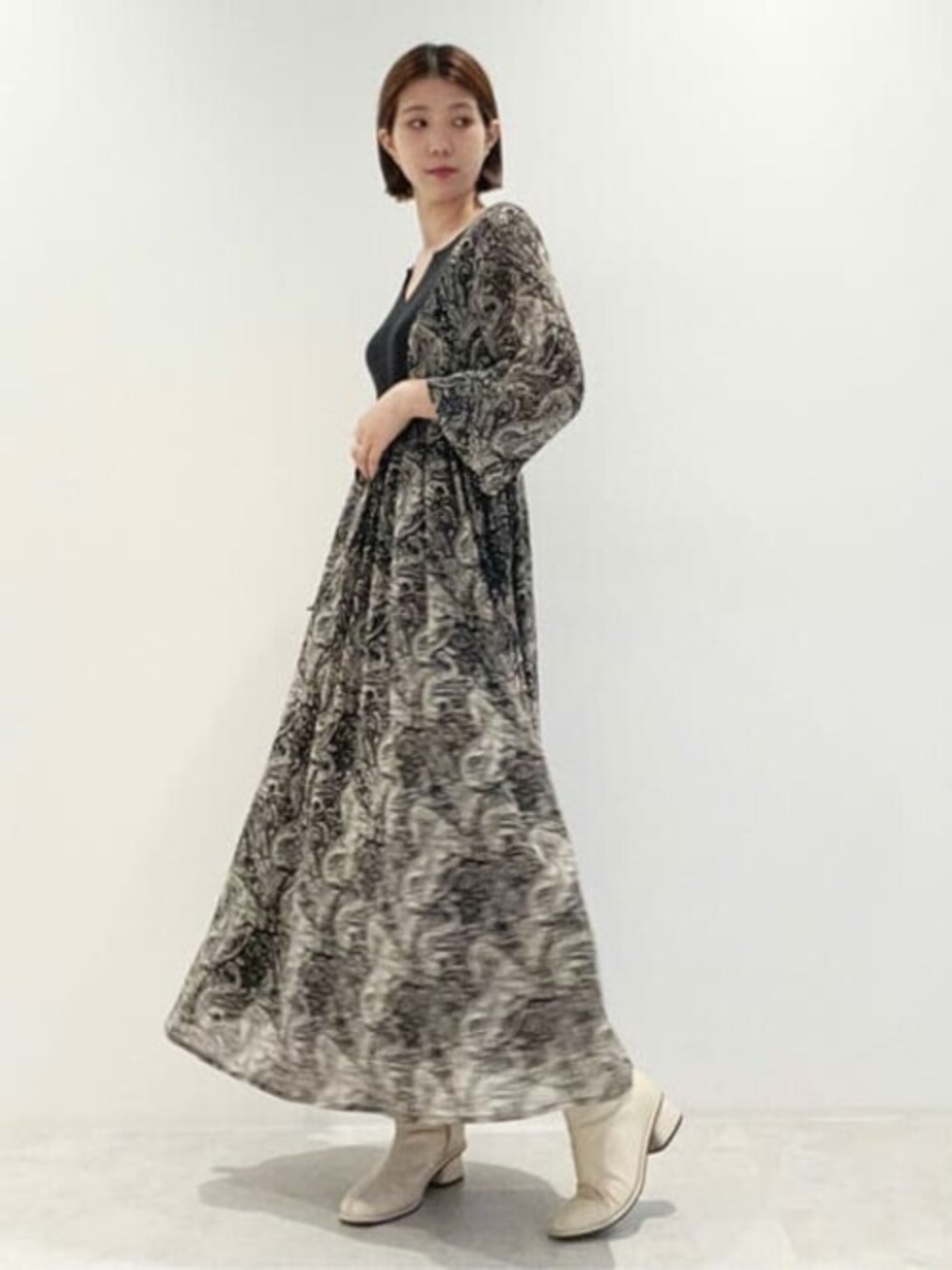 ブラック系のワンピース、ホワイト系のブーツを着用したレディースの秋コーディネートの1枚目の写真