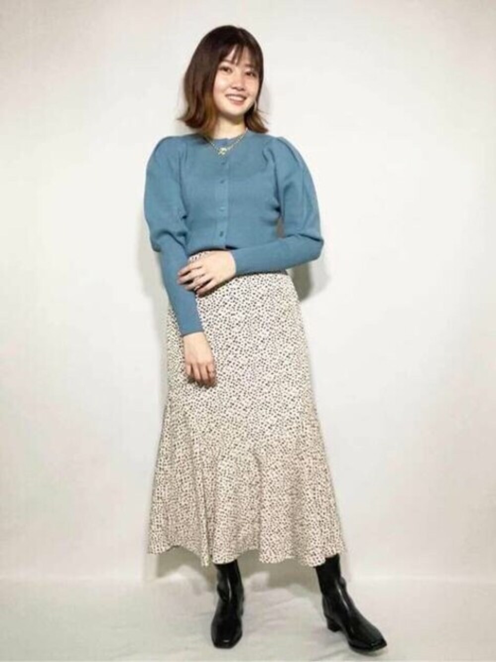 ブルー系のカーディガン/ボレロ、その他のスカート、ブラック系のブーツを着用したレディースの秋コーディネートの1枚目の写真