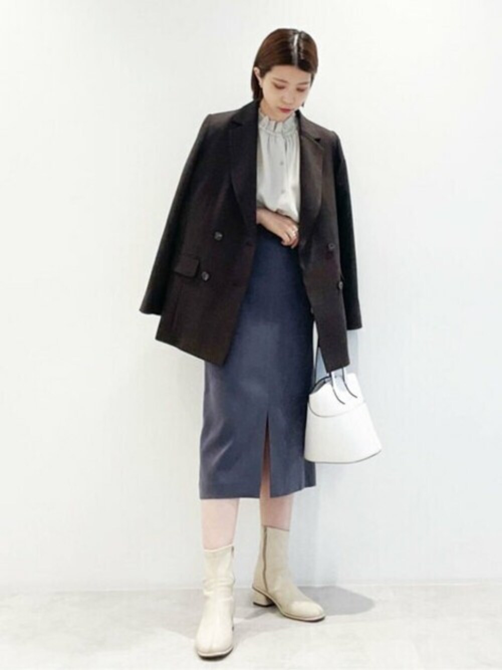 ブラウン系のテーラードジャケット、グレー系のスカート、ホワイト系のトートバッグを着用したレディースの秋コーディネートの1枚目の写真