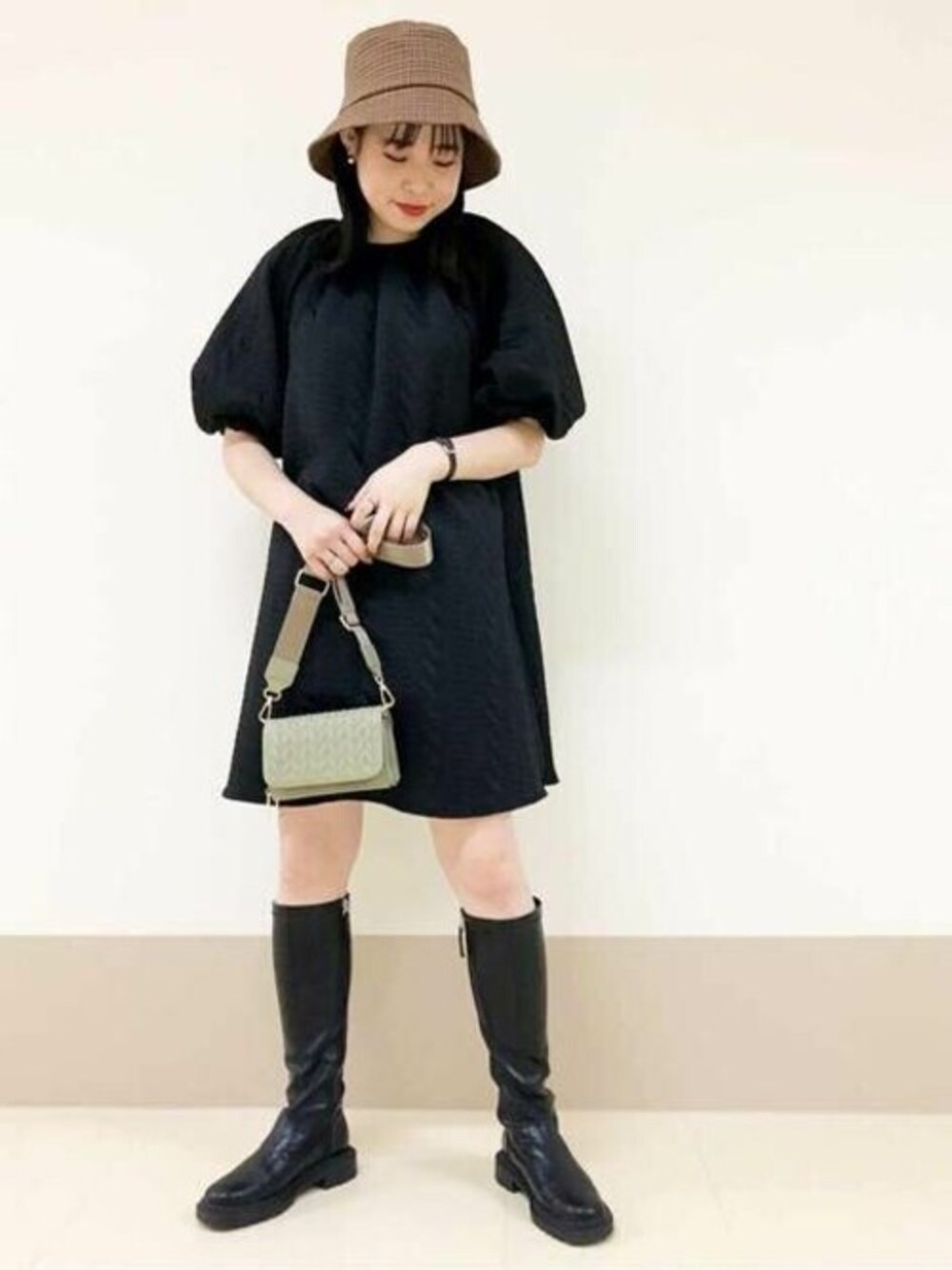ブラック系のワンピース、グリーン系のショルダーバッグ、ブラウン系のハットを着用したレディースの秋コーディネートの1枚目の写真