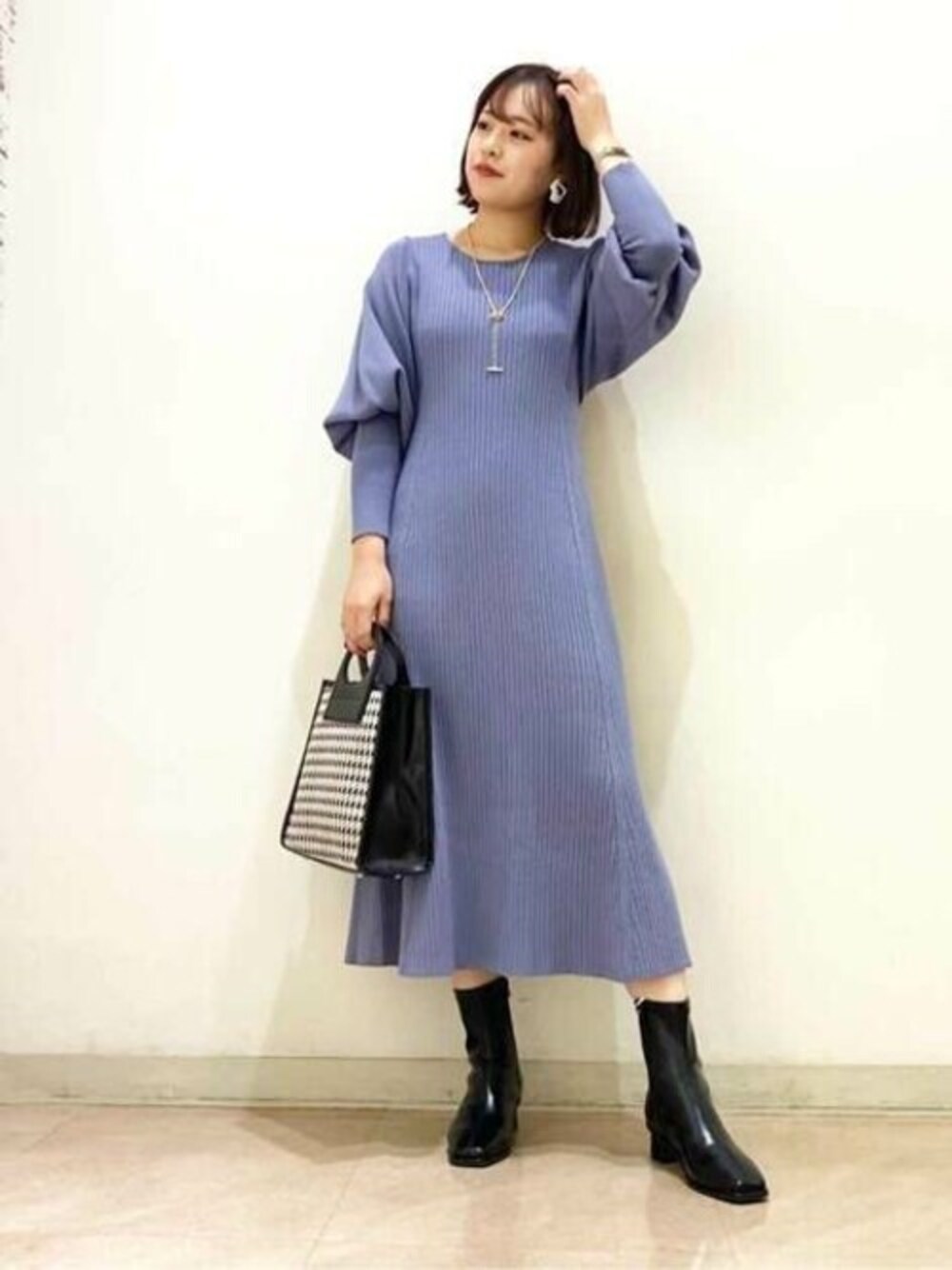 ブルー系のワンピース、ブラック系のトートバッグ、ブラック系のブーツを着用したレディースの秋コーディネートの1枚目の写真