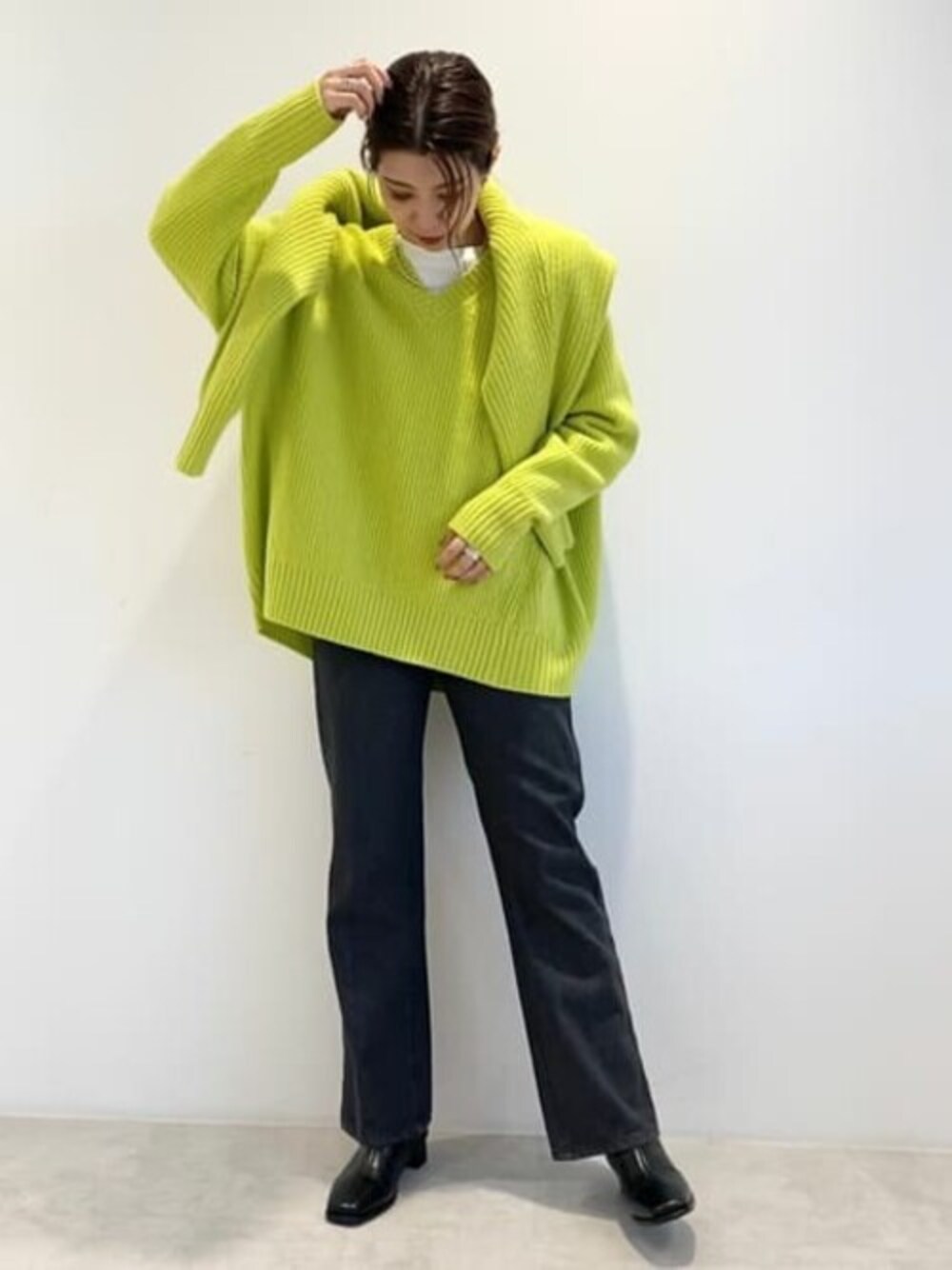 イエロー系のニット/セーター、イエロー系のカーディガン/ボレロ、グレー系のデニムパンツを着用したレディースの秋コーディネートの1枚目の写真