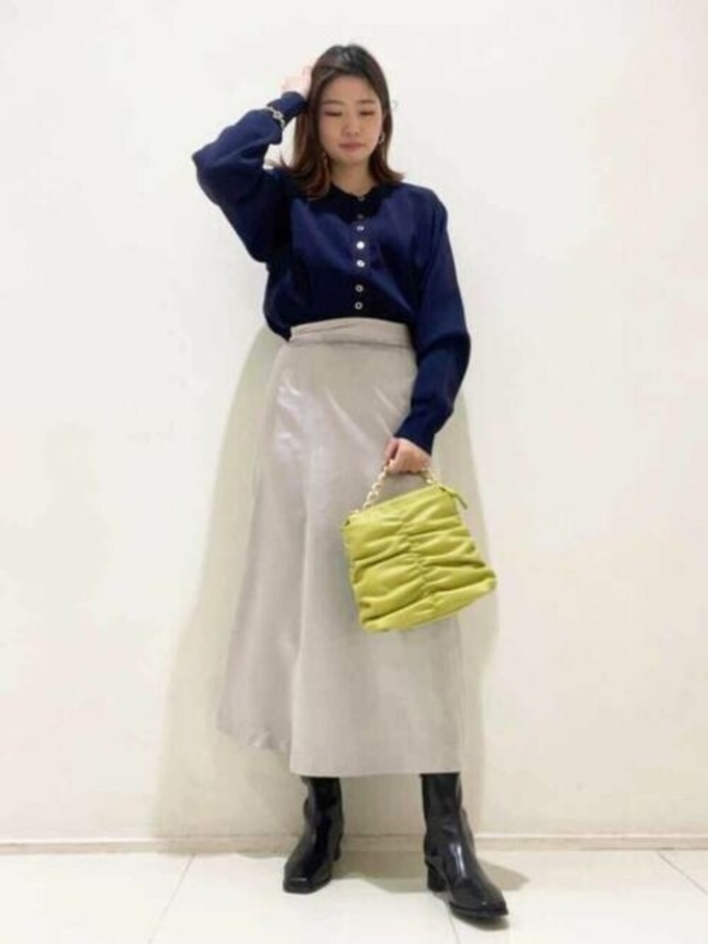 ブルー系のカーディガン/ボレロ、グレー系のスカート、イエロー系のトートバッグを着用したレディースの冬コーディネートの1枚目の写真