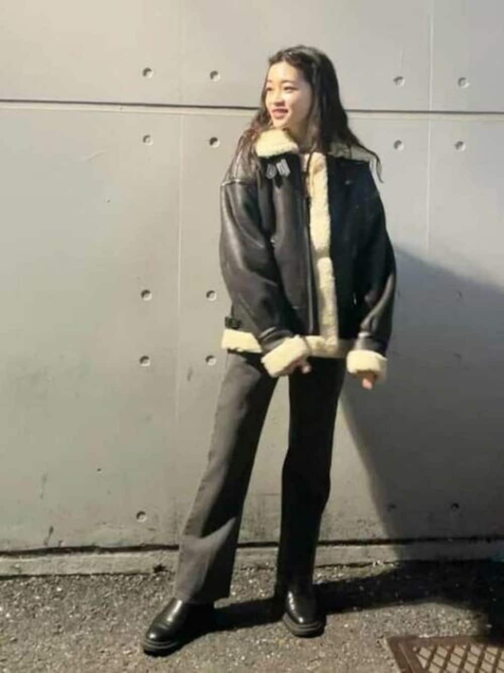 ブラック系のブルゾン、グレー系のデニムパンツ、ブラック系のブーツを着用したレディースの冬コーディネートの1枚目の写真