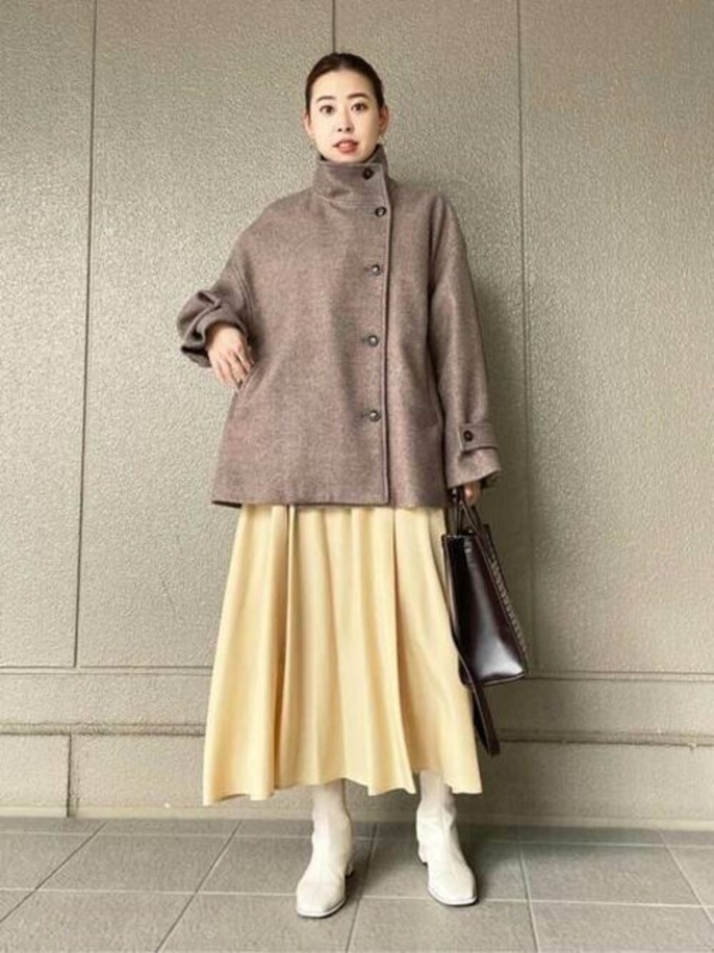 イエロー系のワンピース、ホワイト系のブーツ、ブラウン系のその他アウターを着用したレディースの冬コーディネートの1枚目の写真