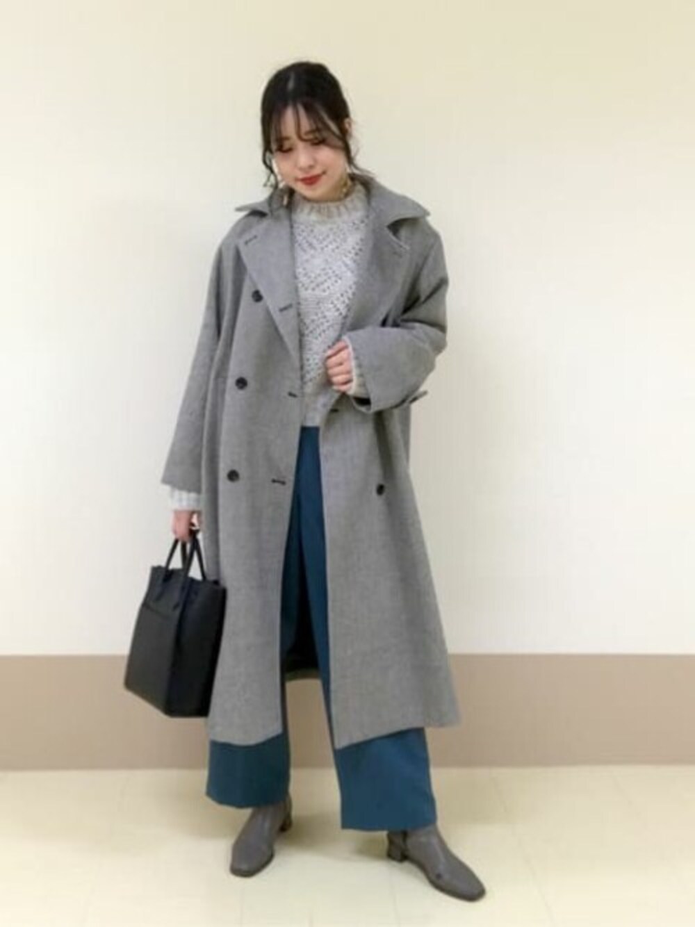 ブルー系のその他パンツ、ホワイト系のニット/セーター、ブラック系のトートバッグを着用したレディースの冬コーディネートの1枚目の写真