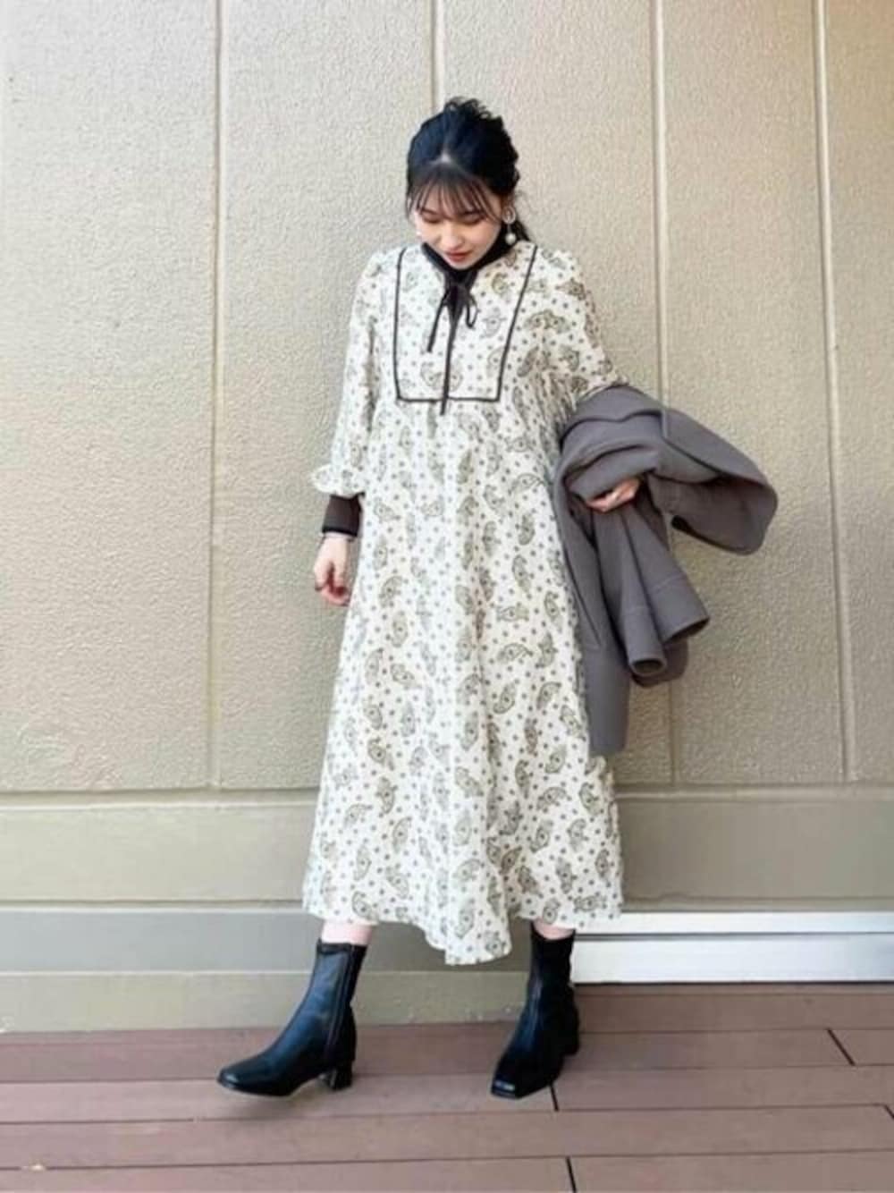 ホワイト系のワンピース、ブラック系のニット/セーター、ブラウン系のその他アウターを着用したレディースの冬コーディネートの1枚目の写真