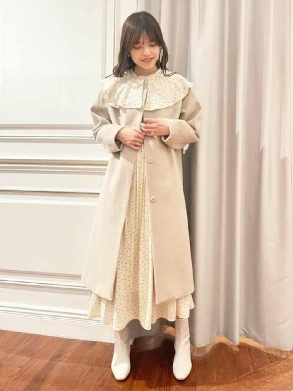 ホワイト系のワンピース、ホワイト系のノーカラーコートを着用したレディースの冬コーディネートの1枚目の写真