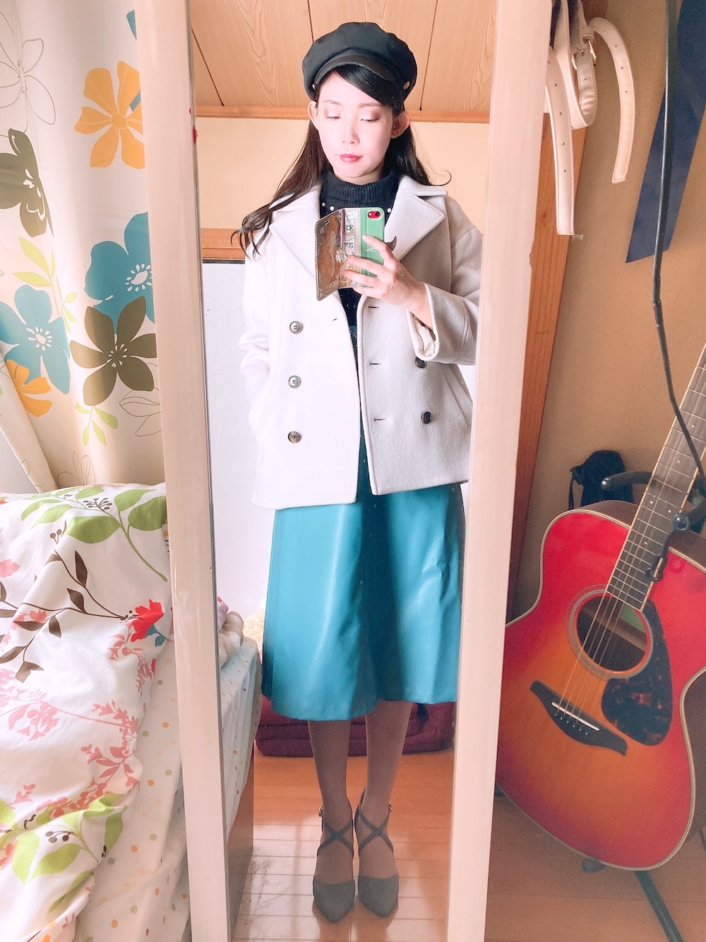 ブラック系のニット/セーター、グレー系のピーコート、ブルー系のスカートを着用したレディースの冬コーディネートの1枚目の写真