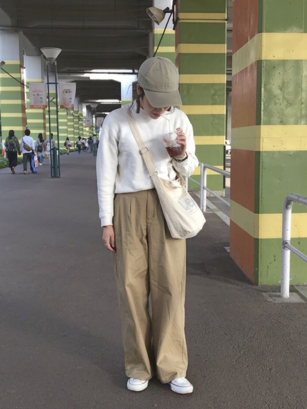 ベージュ系のパンツ、ホワイト系のスウェット、ホワイト系のトートバッグを着用したレディースの秋コーディネートの1枚目の写真