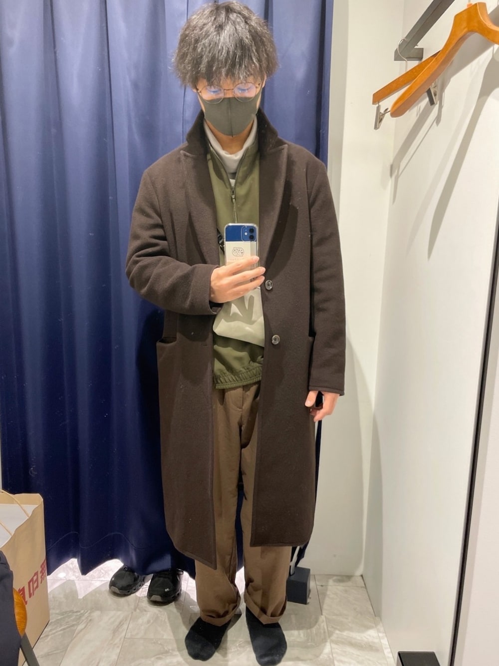 グレー系のTシャツ/カットソー、グリーン系のその他トップス、ブラウン系のチェスターコートを着用したメンズの春コーディネートの1枚目の写真