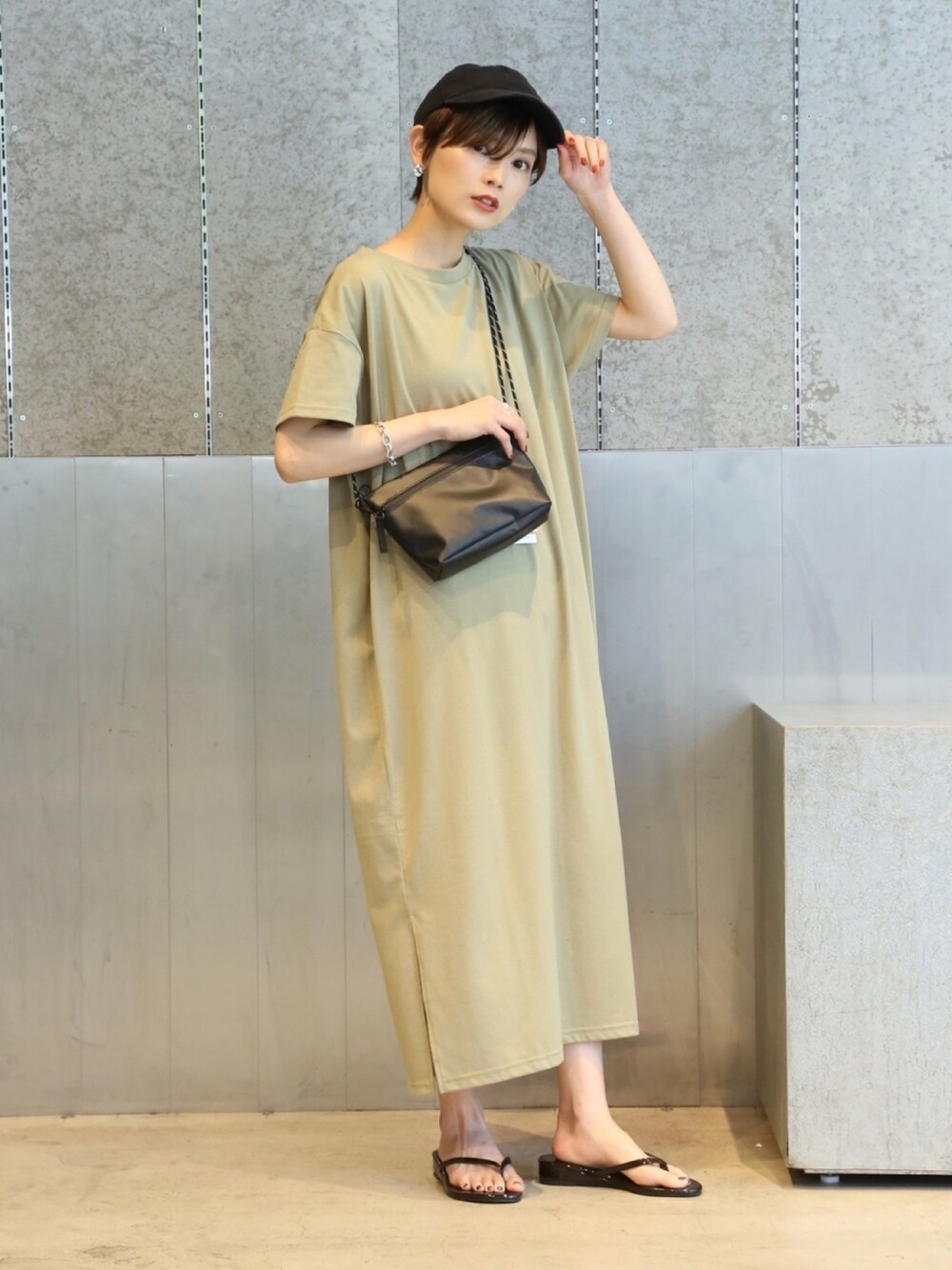 グリーン系のワンピース、ブラック系のショルダーバッグ、ブラウン系のサンダルを着用したレディースの夏コーディネートの1枚目の写真