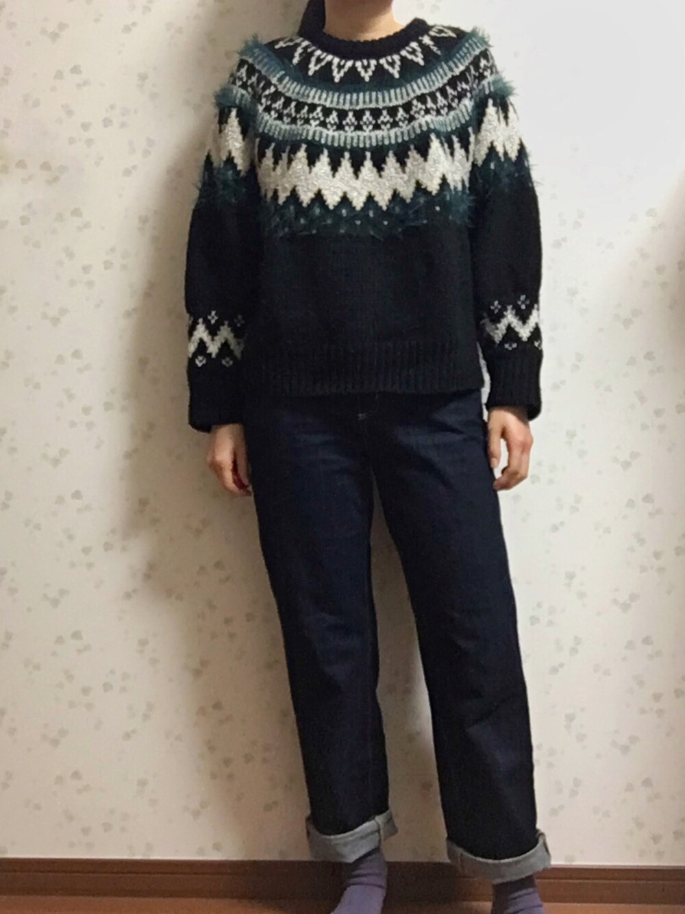 ブラック系のニット/セーター、ブルー系のデニムパンツを着用したレディースの秋コーディネートの1枚目の写真