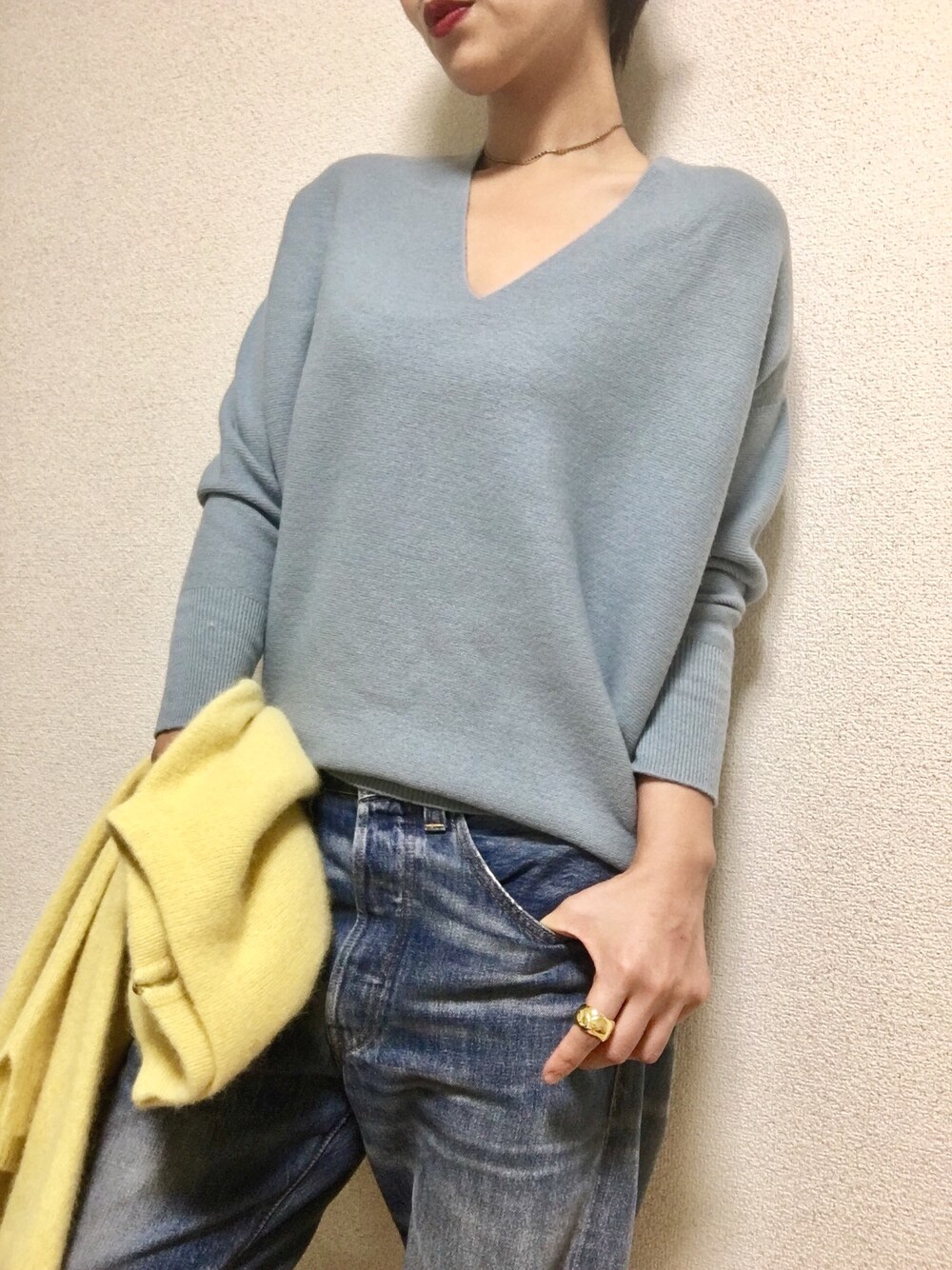 ブルー系のニット/セーター、ブルー系のデニムパンツ、ゴールド系のネックレスを着用したレディースの秋コーディネートの1枚目の写真