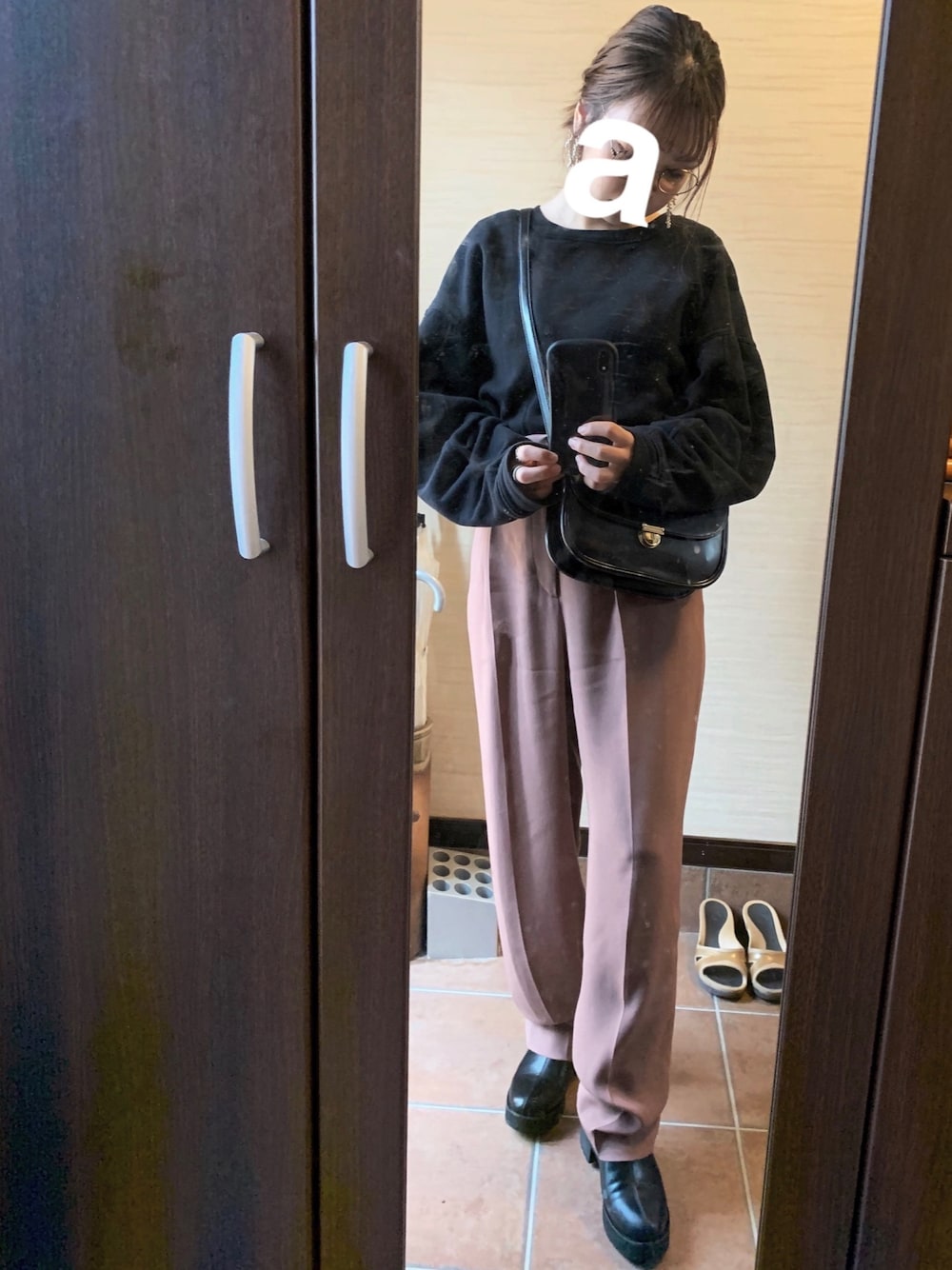 ブラック系のスウェット、ブラウン系のその他パンツ、ブラック系のショルダーバッグを着用したレディースの秋コーディネートの1枚目の写真