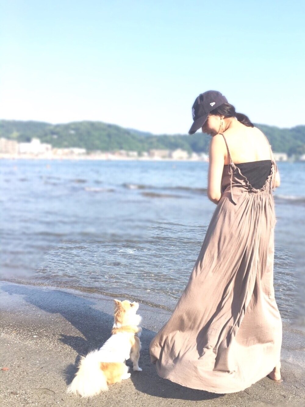 グリーン系のワンピース/ドレス、ブラック系のビーチサンダル、ブルー系のキャップを着用したレディースの春コーディネートの1枚目の写真