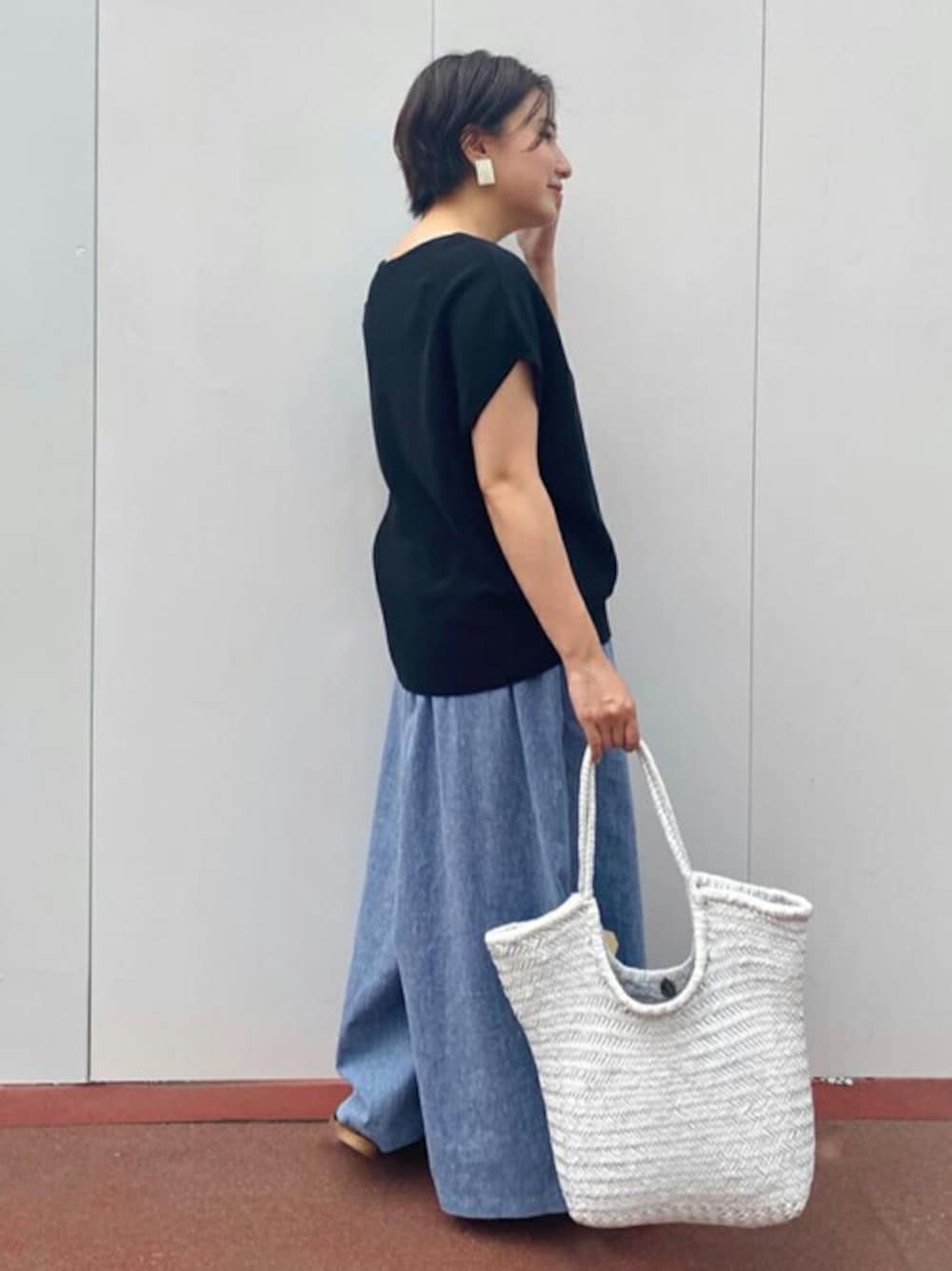 ブラック系のニット/セーター、ブルー系のその他パンツ、ホワイト系のトートバッグを着用したレディースの夏コーディネートの1枚目の写真