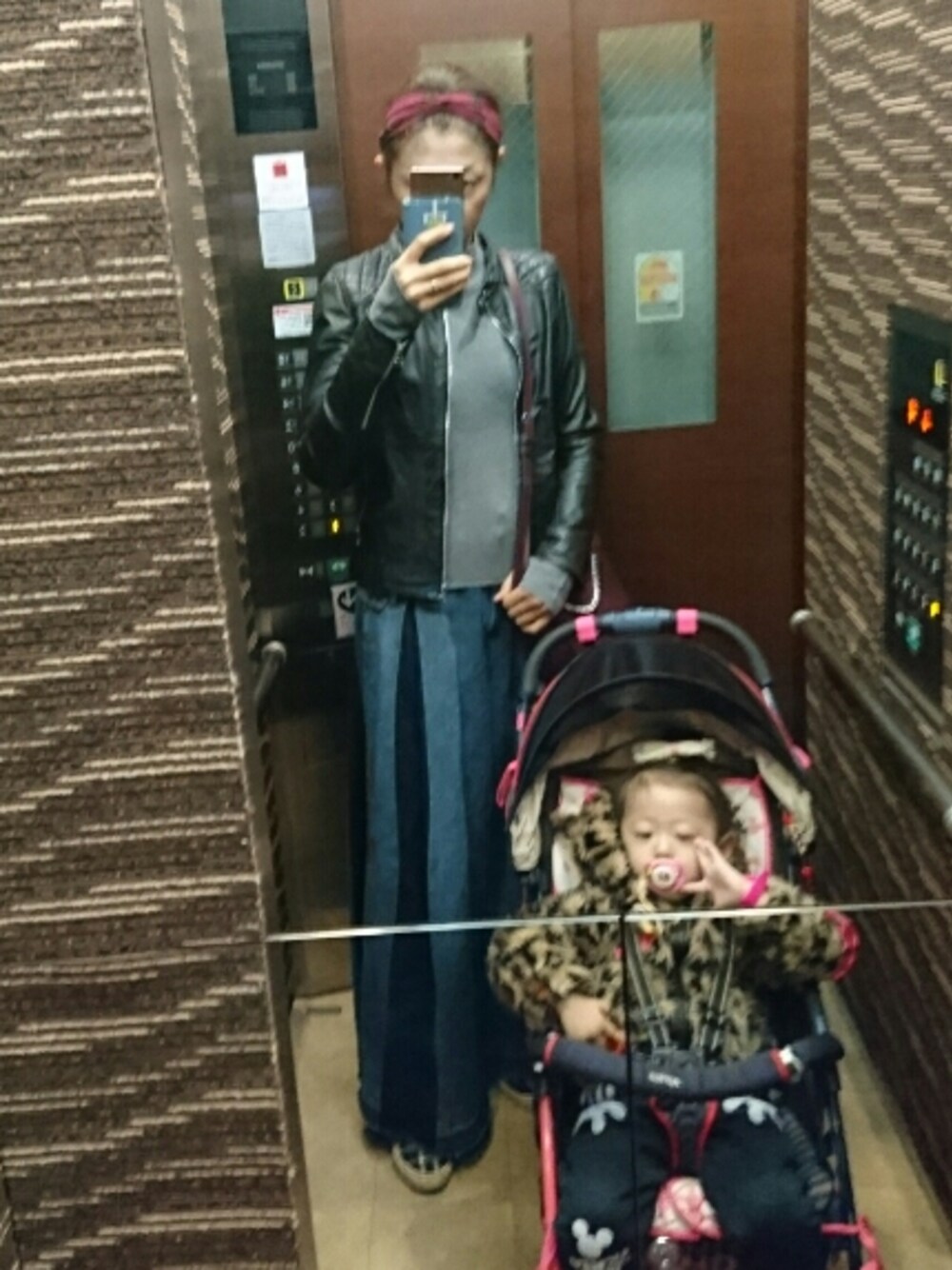 ブルー系のデニムパンツ、グレー系のニット/セーター、ブラック系のライダースジャケットを着用したレディースの冬コーディネートの1枚目の写真