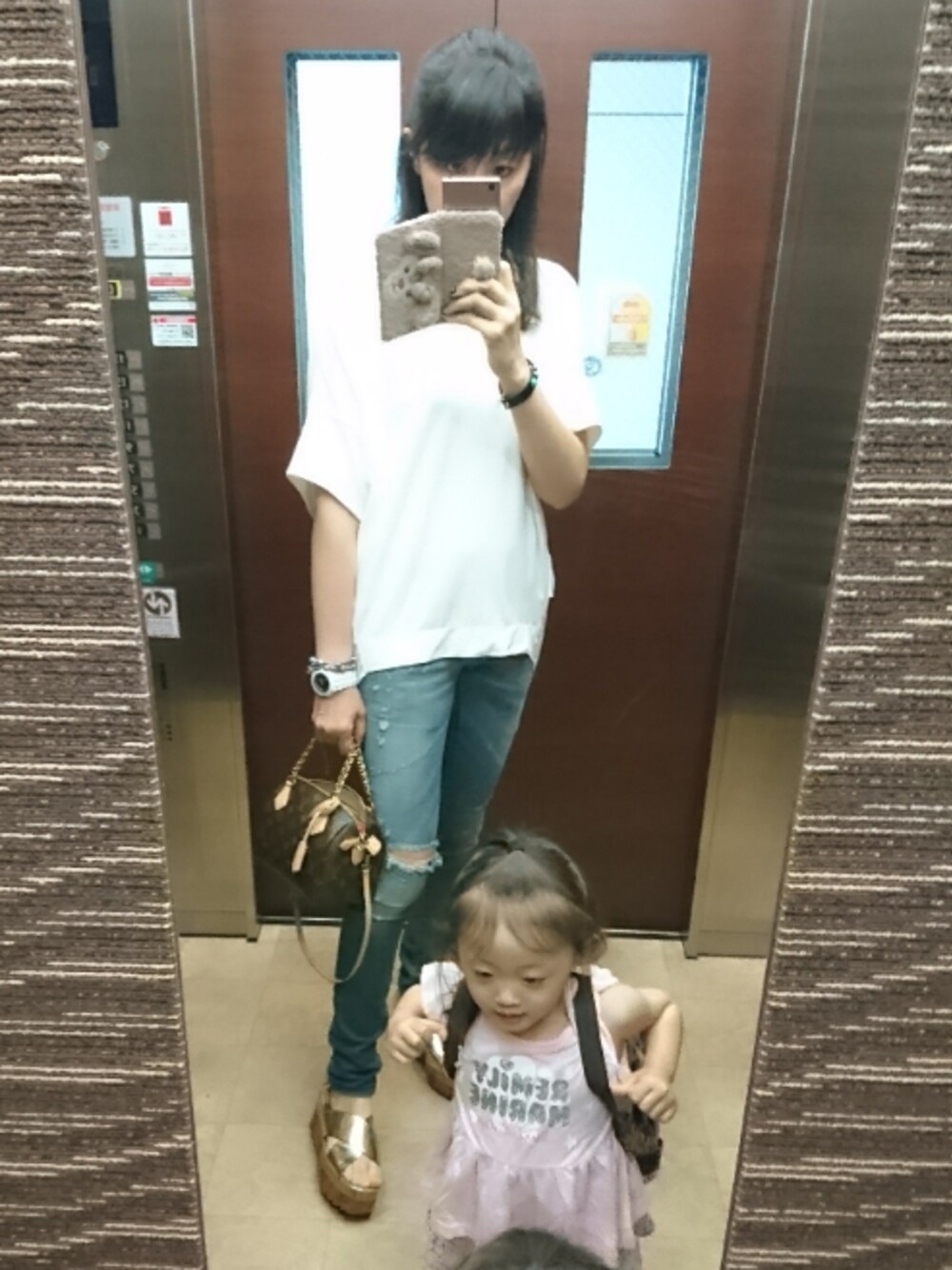ブルー系のデニムパンツ、ホワイト系のTシャツ/カットソー、ブラウン系のバッグを着用したレディースの夏コーディネートの1枚目の写真