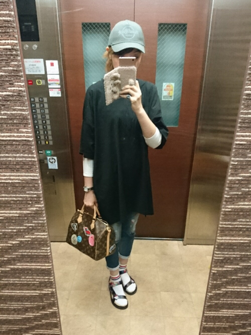 ブラック系のTシャツ/カットソー、ブルー系のデニムパンツ、ブラック系のサンダルを着用したレディースの春コーディネートの1枚目の写真