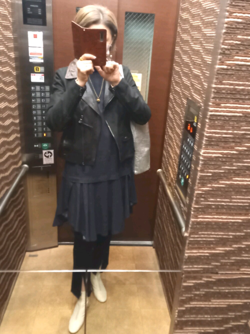ブルー系のワンピース、ブラック系のデニムパンツ、ホワイト系のブーツを着用したレディースの春コーディネートの1枚目の写真