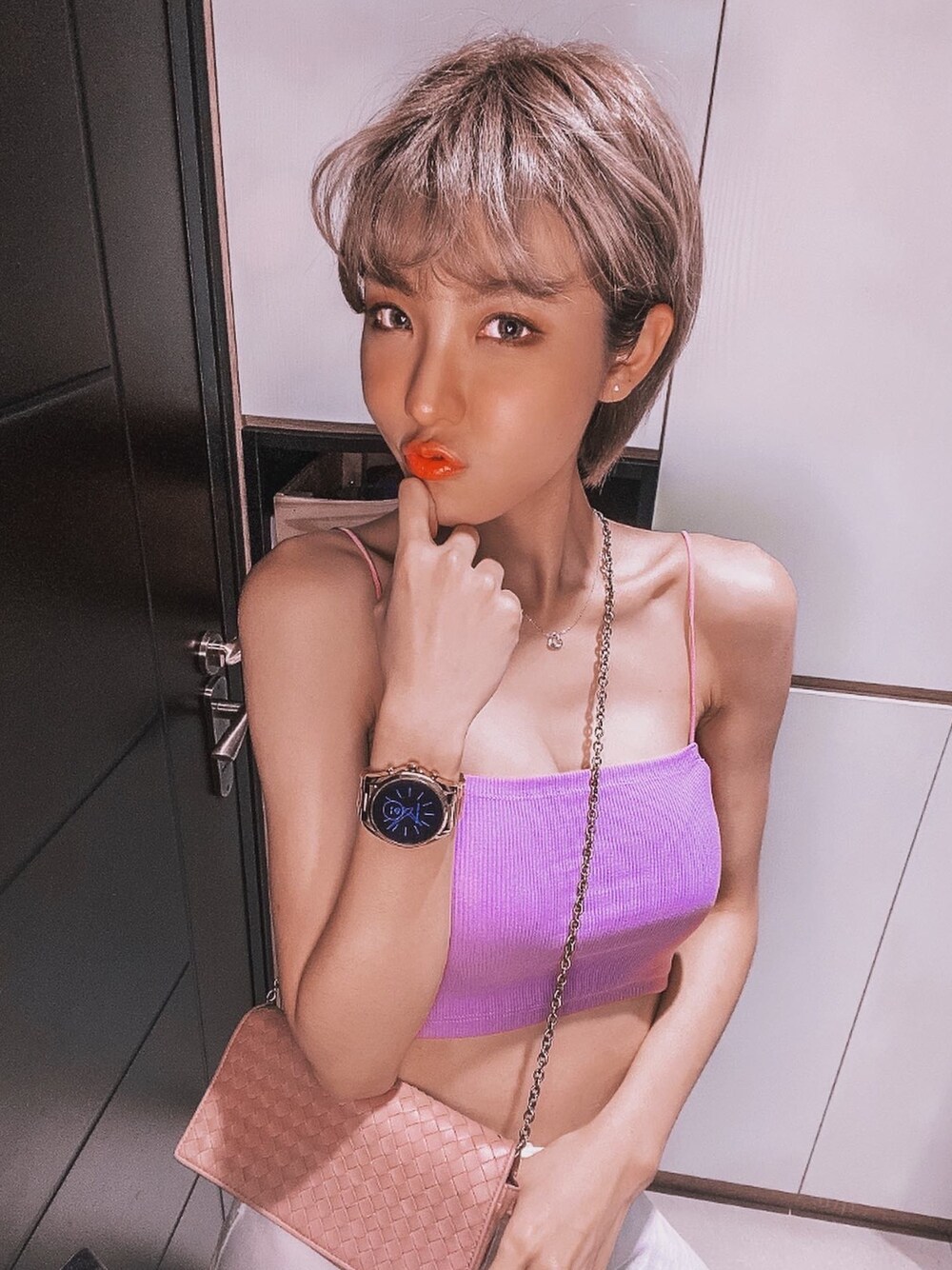 ピンク系のチューブトップ、ピンク系のボディバッグ/ウエストポーチ、ゴールド系の腕時計を着用したレディースの夏コーディネートの1枚目の写真