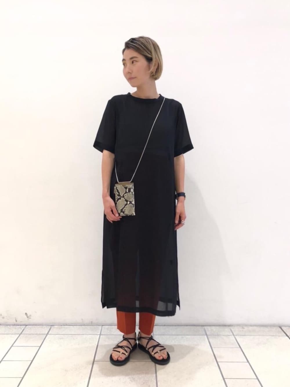 ブラック系のサンダル、ブラック系のワンピース、オレンジ系のその他パンツを着用したレディースの夏コーディネートの1枚目の写真