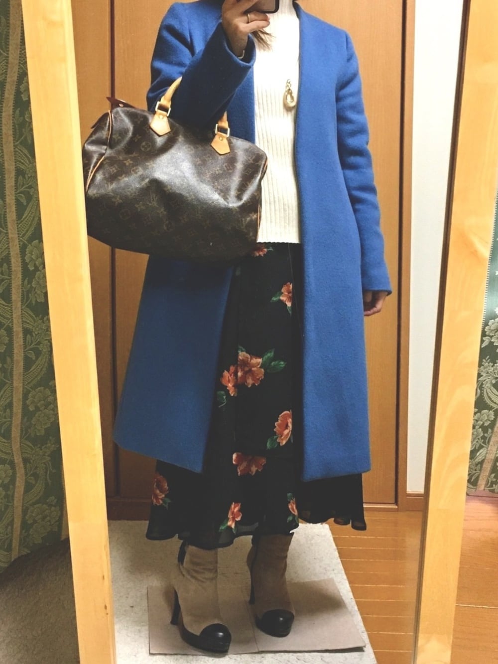 ブラック系のスカート、ブルー系のその他アウター、ホワイト系のニット/セーターを着用したレディースの冬コーディネートの1枚目の写真