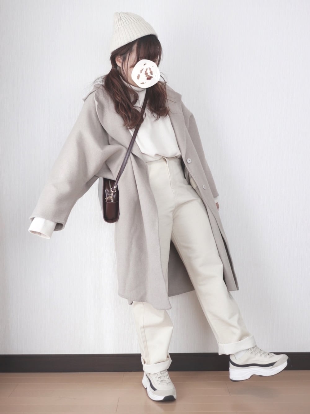 ホワイト系のトップス、ホワイト系のパンツ、ベージュ系のチェスターコートを着用したレディースの冬コーディネートの1枚目の写真