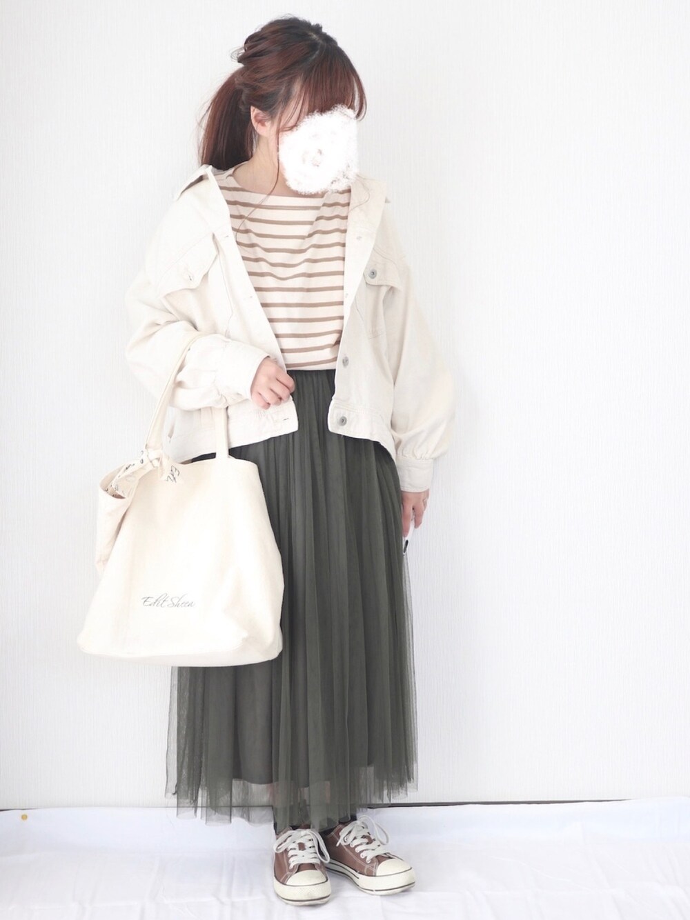 ベージュ系のTシャツ/カットソー、グリーン系のスカート、ホワイト系のデニムジャケットを着用したレディースの春コーディネートの1枚目の写真