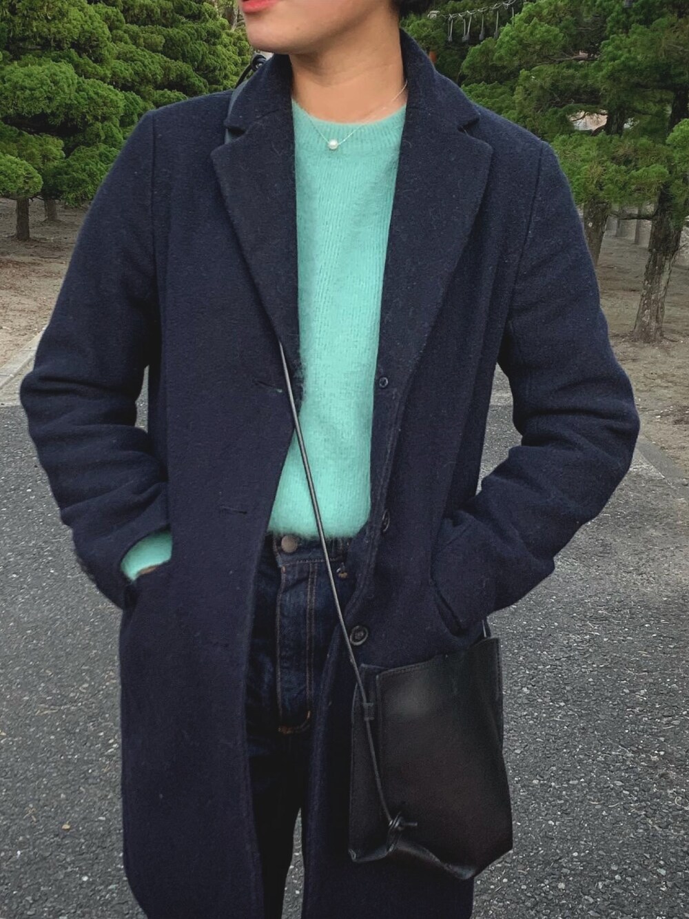 グレー系のチェスターコート、その他のデニムパンツを着用したレディースの冬コーディネートの1枚目の写真