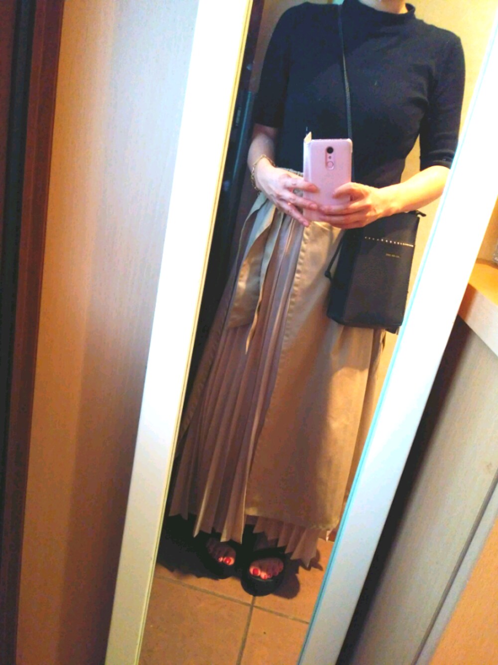 ブラック系のサンダル、ベージュ系のスカート、ブラック系のショルダーバッグを着用したレディースの夏コーディネートの1枚目の写真