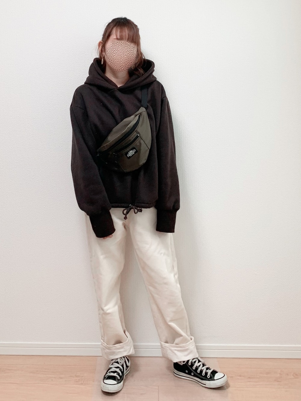 グレー系のパーカー、ホワイト系のパンツ、ブラック系のスニーカーを着用したレディースの冬コーディネートの1枚目の写真