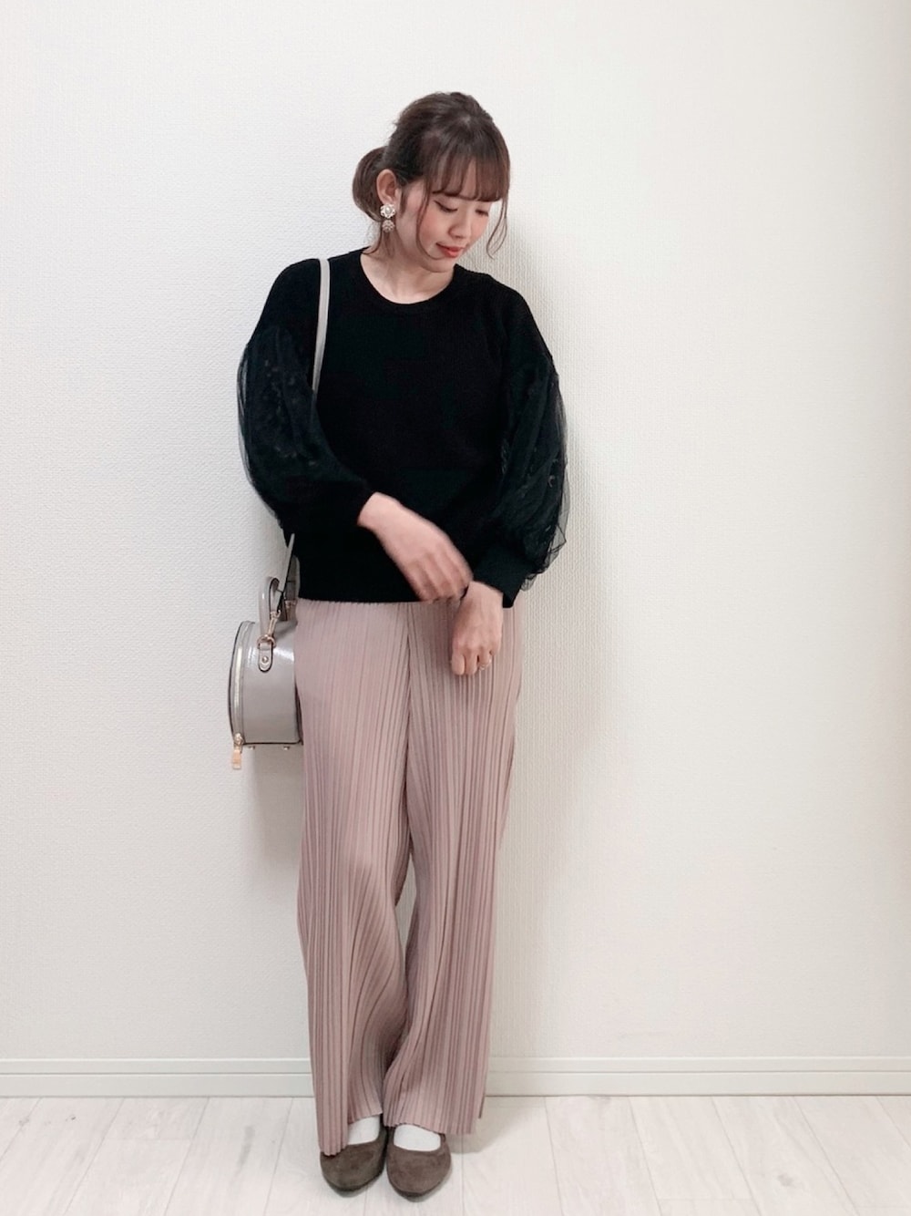 ブラック系のニット/セーター、ピンク系のパンツ、グレー系のバッグを着用したレディースの春コーディネートの1枚目の写真