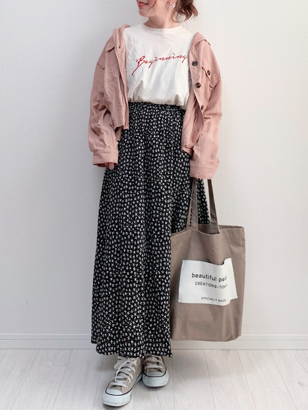 ブラック系のスカート、ホワイト系のTシャツ/カットソー、ベージュ系のシャツ/ブラウスを着用したレディースの春コーディネートの1枚目の写真