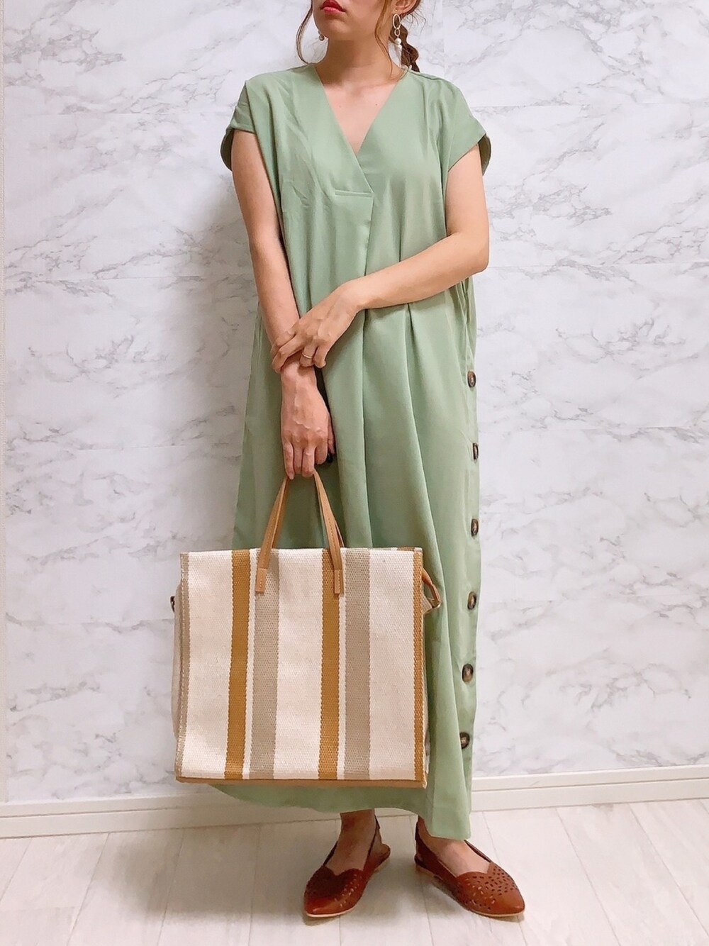 ブラウン系のトートバッグ、グリーン系のワンピース、ブラック系のシューズを着用したレディースの夏コーディネートの1枚目の写真