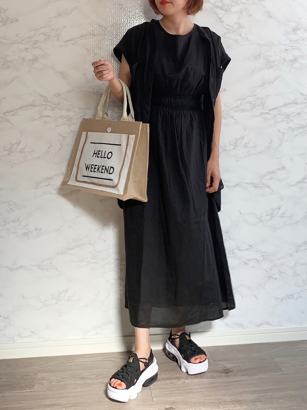 ブラック系のワンピース、ブラック系のシャツ/ブラウス、ホワイト系のサンダルを着用したレディースの夏コーディネートの1枚目の写真