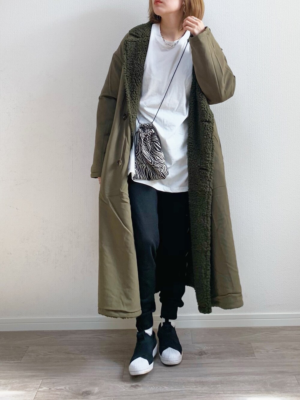 ホワイト系のTシャツ/カットソー、グリーン系のその他アウター、ブラック系のスリッポンを着用したレディースの秋コーディネートの1枚目の写真