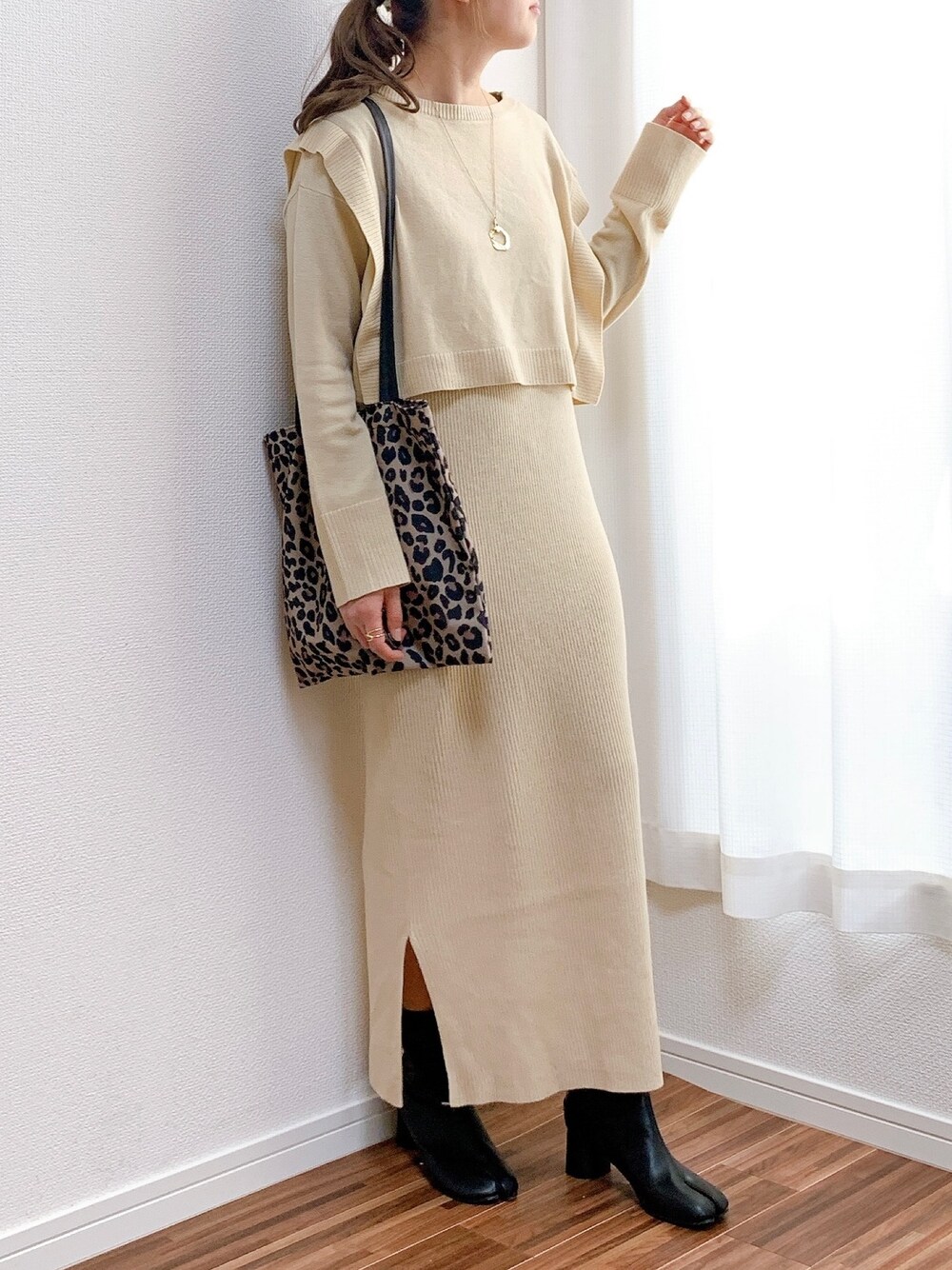 ホワイト系のワンピース、その他のバッグ、ブラック系のブーツを着用したレディースの冬コーディネートの1枚目の写真