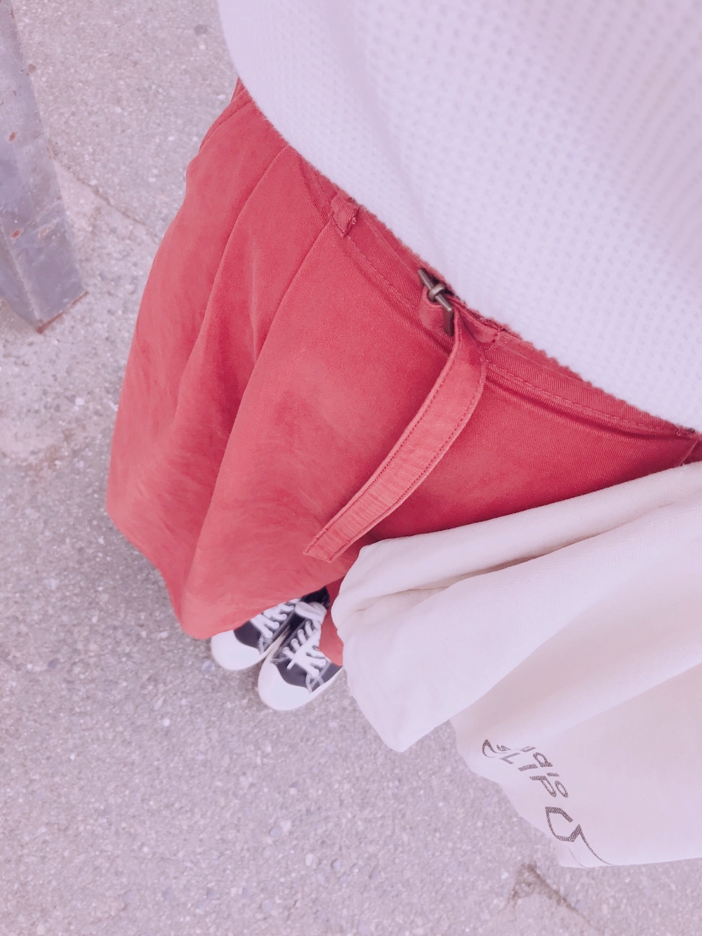 ホワイト系のTシャツ/カットソー、オレンジ系のスカート、ブラック系のスニーカーを着用したレディースの秋コーディネートの1枚目の写真