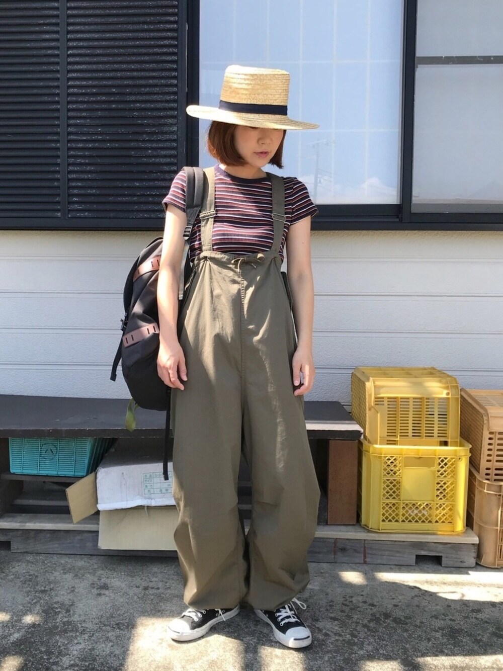 グリーン系のサロペット/オーバーオール、ブルー系のTシャツ/カットソー、ブラック系のバックパック/リュックを着用したレディースの夏コーディネートの1枚目の写真